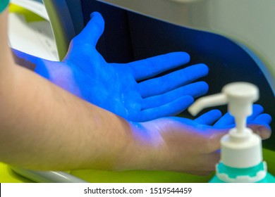 Someone Has Disinfected His Hands And Controls The Result Under Uv Light. Concept: Cleanliness And Protection Against Germs