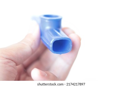 Someone Is Holding A Blue Kazoo, Kazoo Isolated On A White Background. Wind Instrument Idea Concept. A Small Plastic Musical Instrument For Children. Copy Space, Nobody, No People. Music Education.