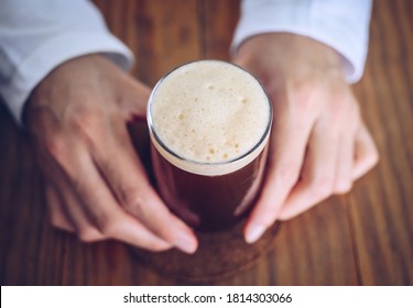 Someone Holding A Glass Of Nitro Cold Brew Coffee. Nitro Coffee Is Unique Type Of Coffee Is Cold-brewed And Infused With Nitrogen Gas To Improve Both Its Taste And Texture.