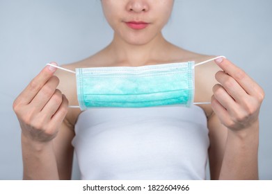 Someone Holding A Surgical Mask Before Wearing. A Surgical Mask Is A Fitting Disposable Mask That Protects The Wearer's Nose And Mouth From Contact With Droplets.