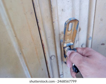 Someone is opening the lock of a door using a key