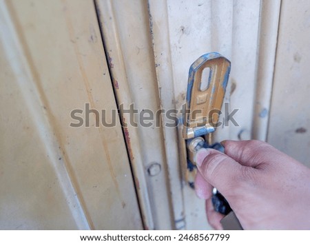 Someone is opening the lock of a door using a key