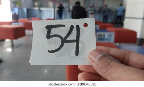 Someone Showing Handwriting Queue Number 54 In The Bank  