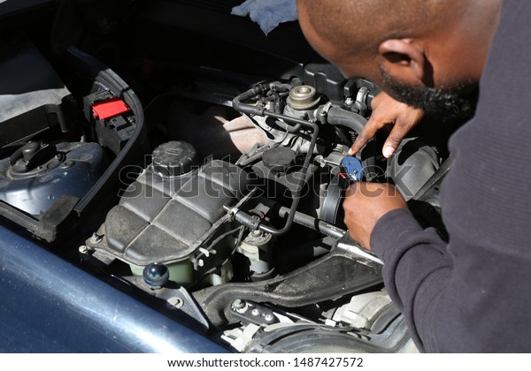 someone under the hood fixing\
a car