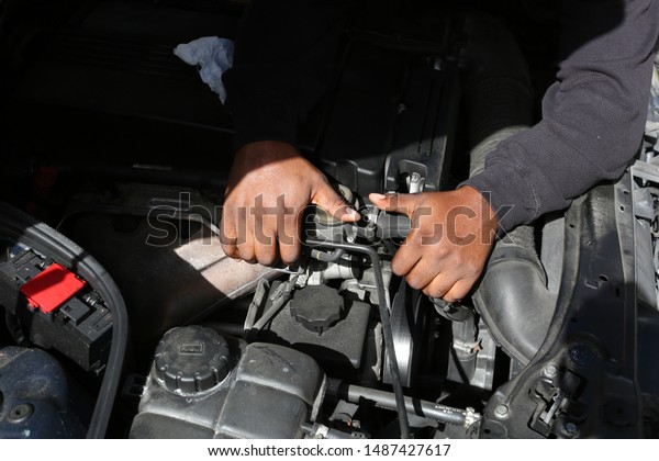 someone under the hood fixing\
a car