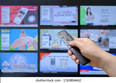 Someone Who Searches TV Home Shopping Channels With A Remote Control In His Hand.