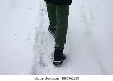 someone's feet are walking in the snow