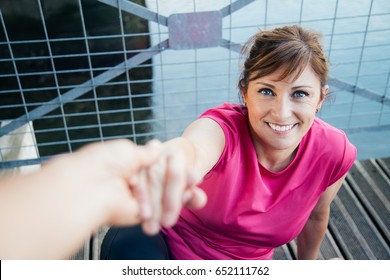 Someones Hand Helping Middle Aged Woman To Get Up From The Floor Before Running. Point Of View Shot