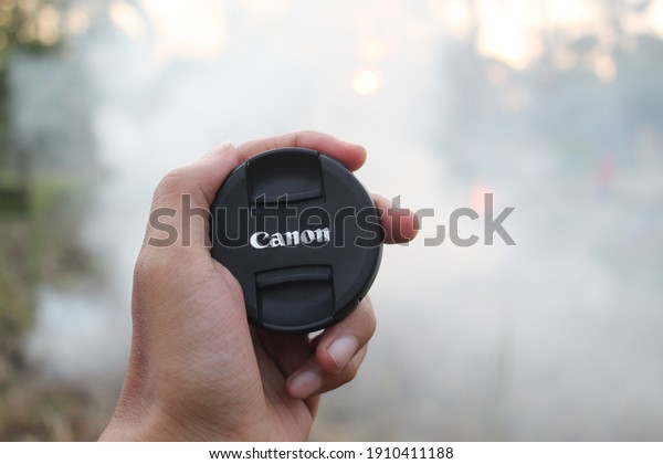someone\'s\
hand holding the canon lens cap, its\
Beautiful