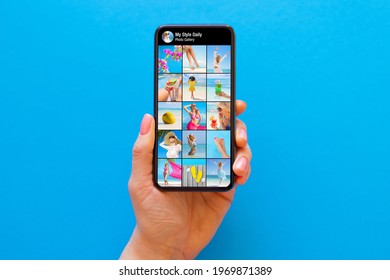 Someone's photo gallery on social media shown on the screen of mobile phone on blue background