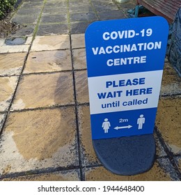 Somerset, UK - Mar26, 2021:  Covid Signage Outside On Path By Community Hall Entrance