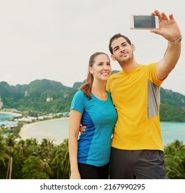 Something To Send Home To Our Parents. Shot Of A Happy Young Couple Taking A Selfie On An Island Vacation.