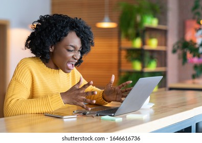 Something went wrong. Angry black businesswoman screaming at laptop screen, working at cafe, copy space - Shutterstock ID 1646616736