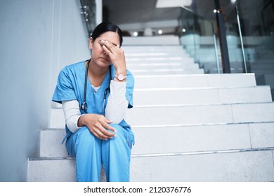 Sometimes not everything is in our hands. Shot of a female nurse looking stressed while sitting on a staircase. - Powered by Shutterstock