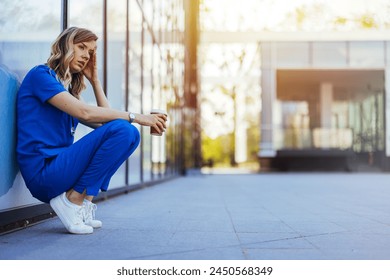 Sometimes not everything is in our hands. Female nurse looking stressed while sitting outdoors of the hospital. Sad or crying female nurse. Clinic and hospital medical stuff working over hours.  - Powered by Shutterstock