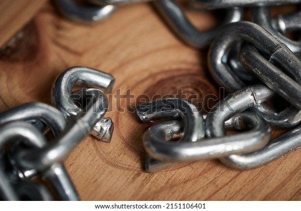 Sometimes you just have to let go. Shot of metal\
chains with a broken\
link.