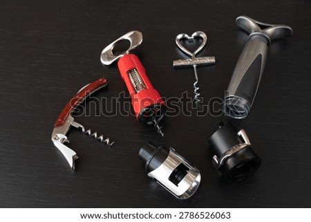 Sommelier kit includes waiter corkscrew and  vacuum stopper, sommelier tool selection displayed on elegant black background, sommelier accessory set makes perfect gift for wine enthusiast. 