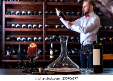 Sommelier Looking For Good Wine On The Storage In The Wine Cellar