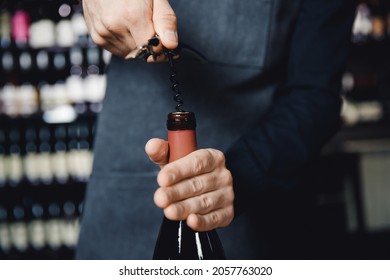 Sommelier opens cork of bottle of red wine with corkscrew. - Powered by Shutterstock