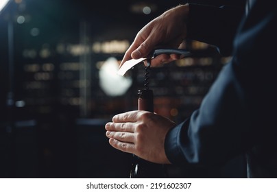 Sommelier opens cork of bottle of red wine with corkscrew. - Powered by Shutterstock