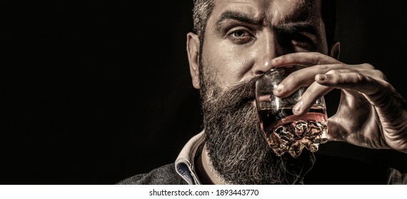  Sommelier Tastes Drink. Man Holding A Glass Of Whisky. Sipping Whiskey. Man With Beard Holds Glass Brandy.