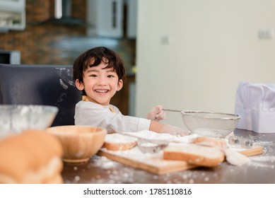 Son Cooking Food. Preparing An Ingredient With Flour And Bread. Kid Daily Lifestyle At Home. Asian Family In The Kitchen.