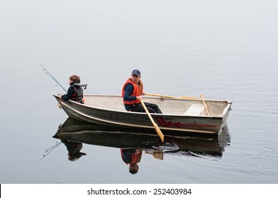 Son And Dad Fishing In A Row Boat