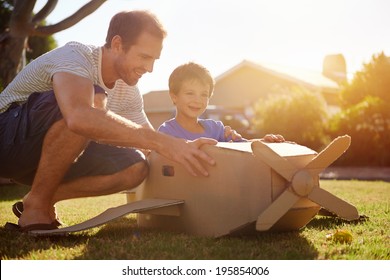 son and dad playing with toy aeroplane in the garden at home having fun together and smiling - Powered by Shutterstock