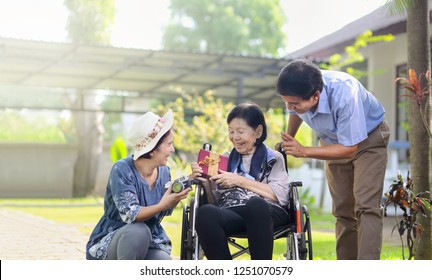 Son And Daughter In Law Gift Elderly Mother In Backyard