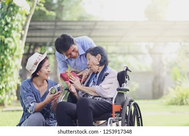 Son And Daughter In Law Gift Elderly Mother In Backyard