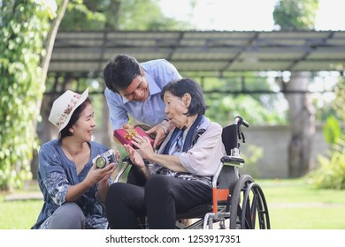 Son And Daughter In Law Gift Elderly Mother In Backyard