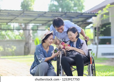 Son And Daughter In Law Gift Elderly Mother In Backyard