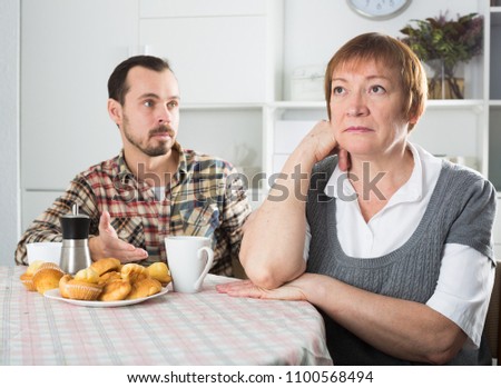 Son defends his position before adult mother at home