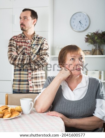 Son defends his position before adult mother at home