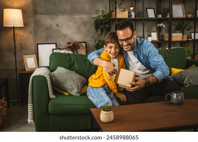 Son give and share gift with his father and surprise him for birthday or fathers day - Powered by Shutterstock