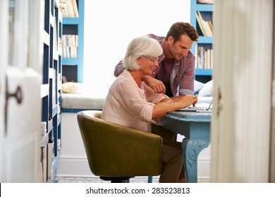 Son Giving Senior Parent Financial Advice In Home Office