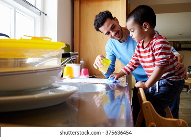 Sohn, der dem Vater hilft, Geschirr im Küchenschacht zu waschen