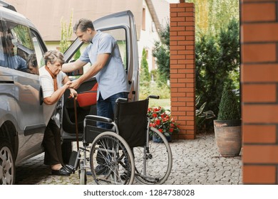 Son Is Helping His Elder Mother To Get Out Of The Car