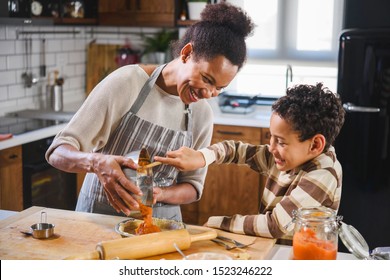 Son is helping mother to prepare pumpkin pie. American family. Single mother. Household chores for kids. - Powered by Shutterstock