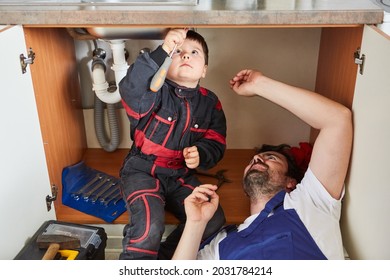 Son Helps Dad As A Handyman Install A Sink In The Kitchen