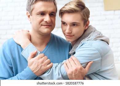 Son Hugs Beloved Dad Who Holds His Hand. Dad And Son Made Friends And Established Family Relationships.