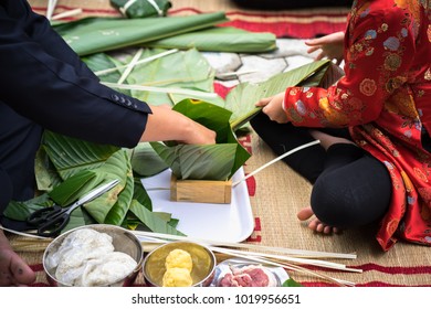 The son learning to make Chung cake by hands with his father closeup, Chung cake is the most important traditional Vietnamese lunar New Year (Tet) food.