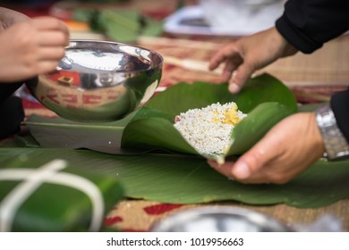 The son learning to make Chung cake by hands with his father closeup, Chung cake is the most important traditional Vietnamese lunar New Year (Tet) food.