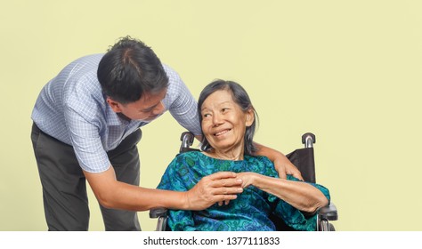 Son Looking After Elderly Mother On Wheelchair