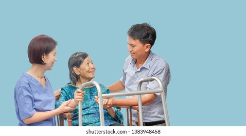 Son Looking After Elderly Mother On Wheelchair With Caregiver