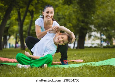 son and mother are doing exercises in the park - Powered by Shutterstock