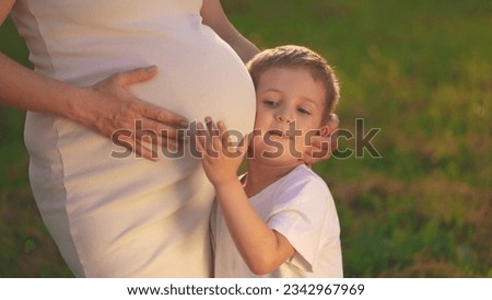 a son pregnant mother. little boy hugs his pregnant mom belly. son pregnant mom happy family kid dream concept.woman experiences motherhood for second time, boy will become the older brother lifestyle