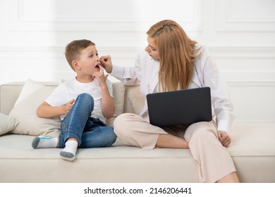 The Son Shows His Mother That He Has A Toothache. Mom Looks At Her Son's Teeth.