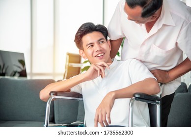 Son Is In A Wheelchair And An Asian Senior Father Is Taking His Son Out Of The Hospital To Go Home. Concept Healt Care