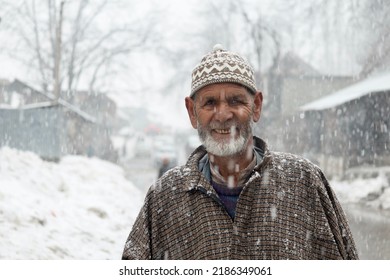 Sonamarg, Jammu and Kashmir, India - March 1 2022: A headshot portrait of an old Kashmiri Indian man taken during heavy snowfall.